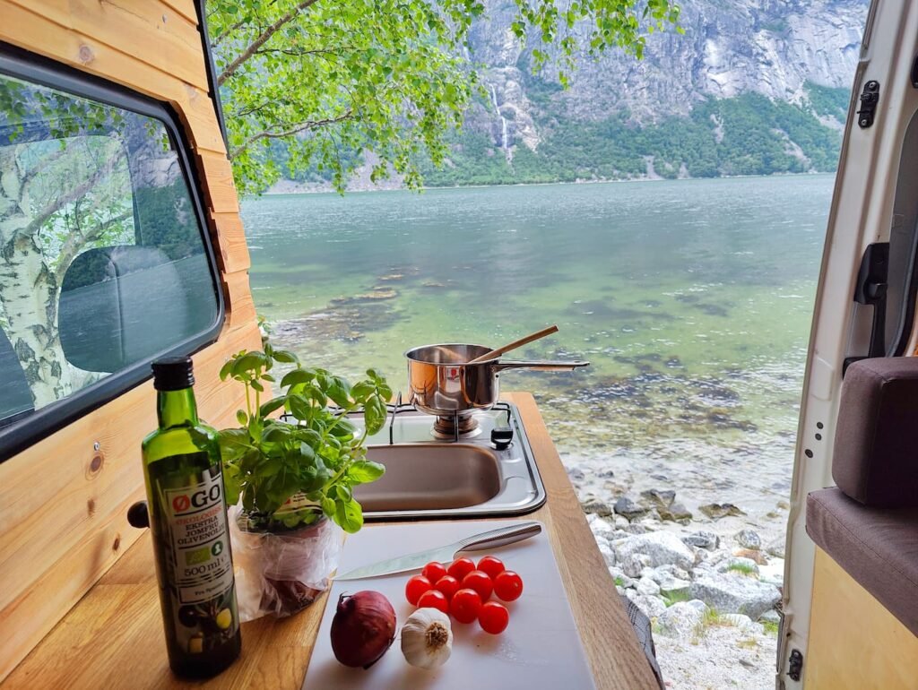 Cooking inside a Cabin Campers campervan by a beautiful Norwegian fjord.