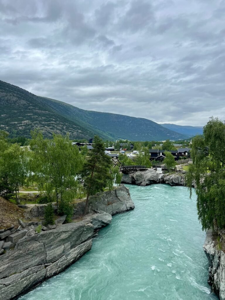 Turquoise glacial river flowing through Lom, surrounded by mountains and beautiful Norwegian nature.